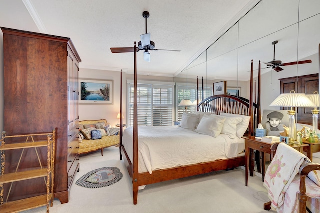 bedroom with a textured ceiling, ornamental molding, light colored carpet, and ceiling fan