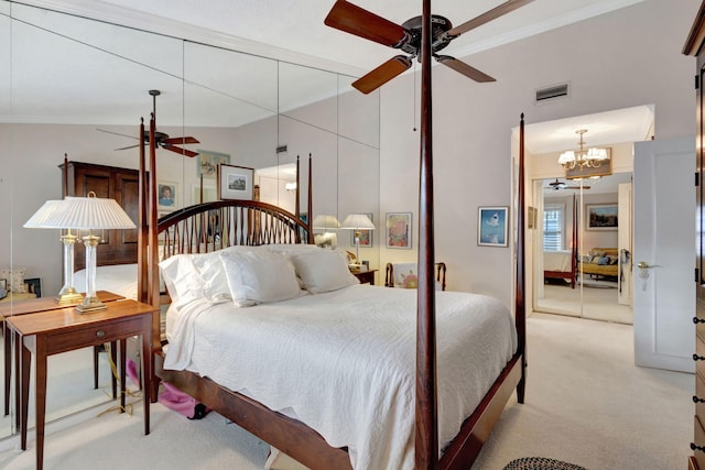 carpeted bedroom with ornamental molding, vaulted ceiling, and ceiling fan with notable chandelier