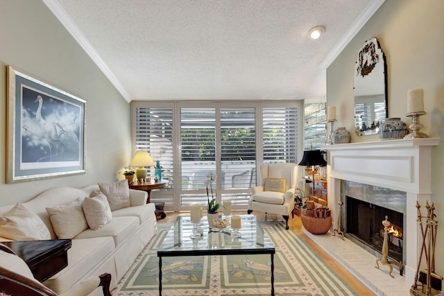 living room with a textured ceiling, ornamental molding, and light wood-type flooring