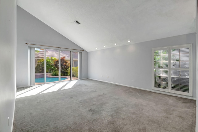 empty room with high vaulted ceiling, carpet flooring, and a healthy amount of sunlight