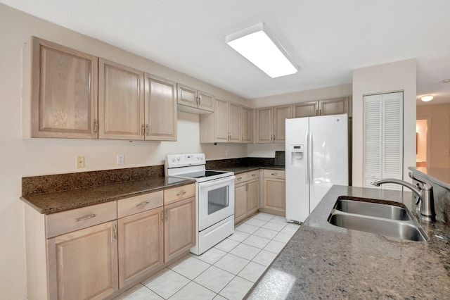 kitchen featuring dark stone counters, light tile patterned floors, light brown cabinets, sink, and white appliances