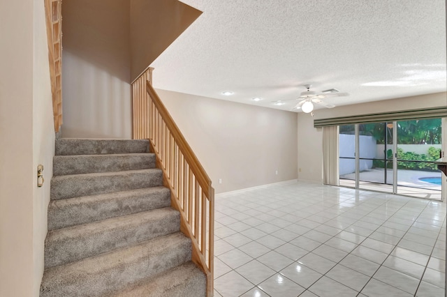 staircase with tile patterned floors and ceiling fan