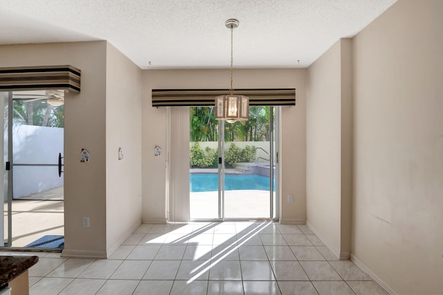 unfurnished dining area with a healthy amount of sunlight, light tile patterned floors, and a textured ceiling