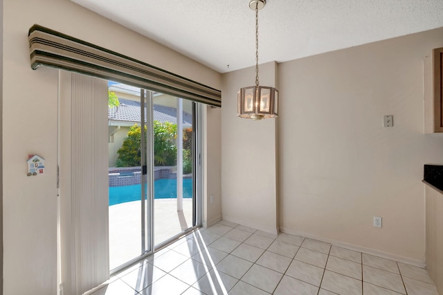 unfurnished dining area with a textured ceiling, light tile patterned floors, and an inviting chandelier