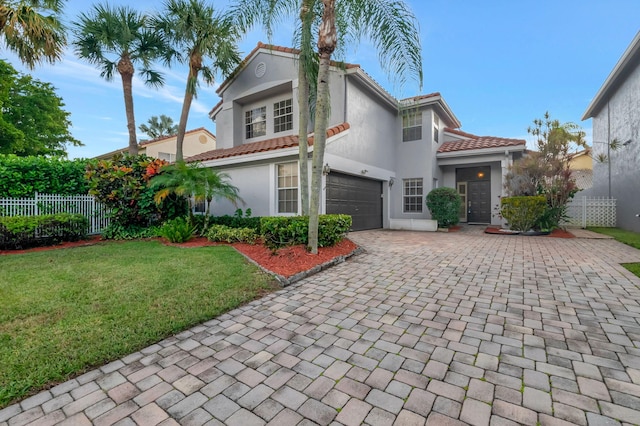 mediterranean / spanish-style home featuring a garage and a front lawn