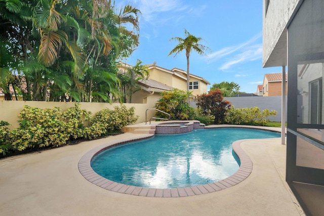 view of swimming pool featuring a patio area and an in ground hot tub