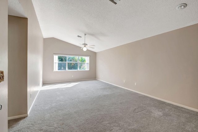 carpeted spare room featuring a textured ceiling, lofted ceiling, and ceiling fan