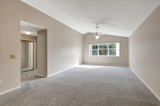 carpeted spare room featuring ceiling fan, a textured ceiling, and vaulted ceiling