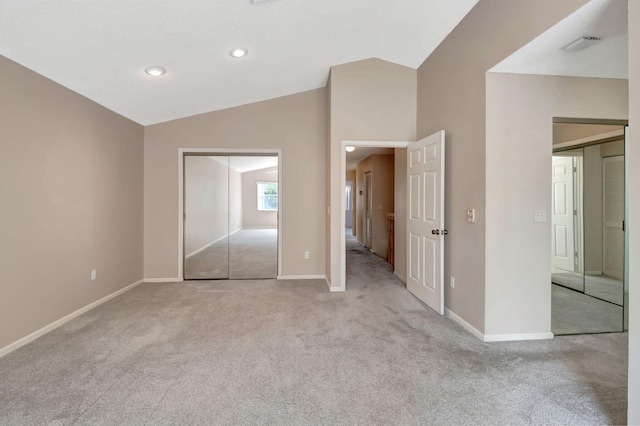 unfurnished bedroom with a closet, vaulted ceiling, and light colored carpet