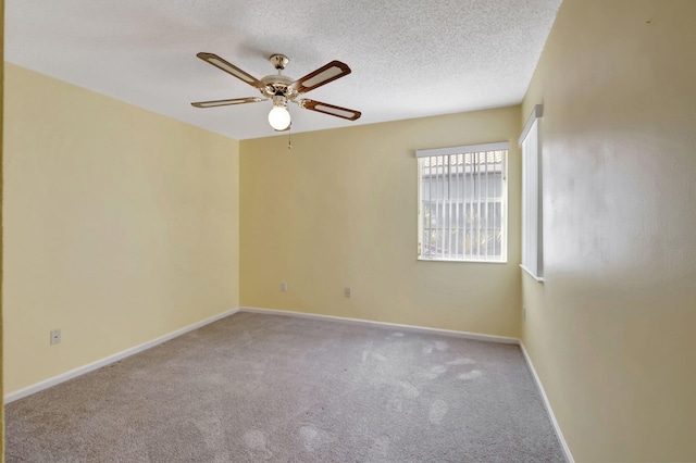 carpeted spare room featuring a textured ceiling and ceiling fan