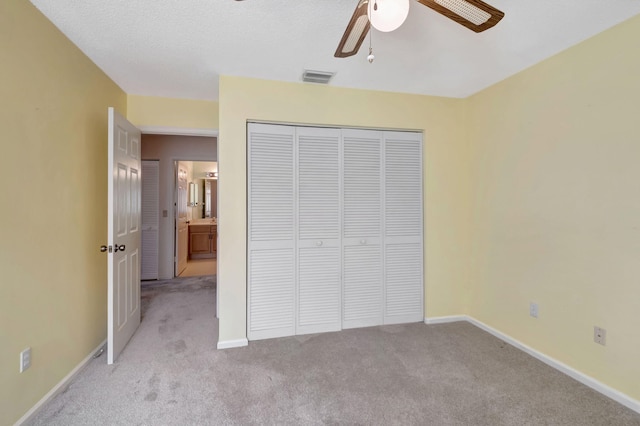 unfurnished bedroom with a closet, light carpet, and ceiling fan