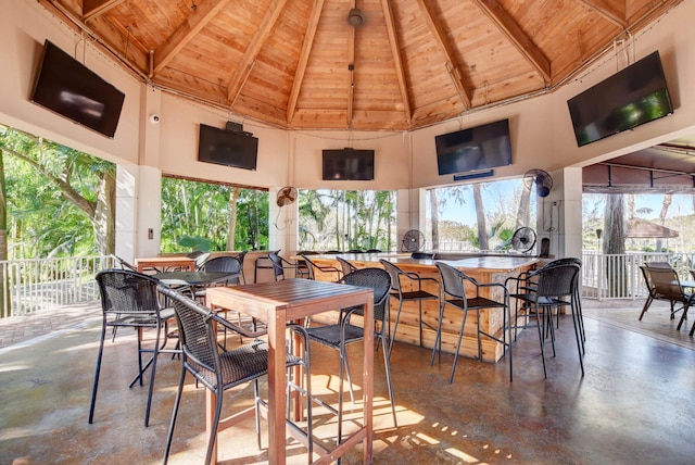 sunroom / solarium featuring vaulted ceiling with beams and wood ceiling