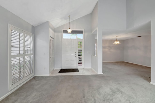 entrance foyer featuring high vaulted ceiling and light carpet