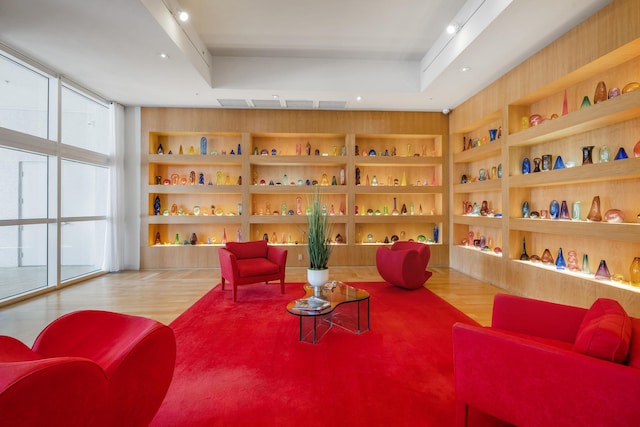 sitting room with hardwood / wood-style flooring, floor to ceiling windows, and built in shelves