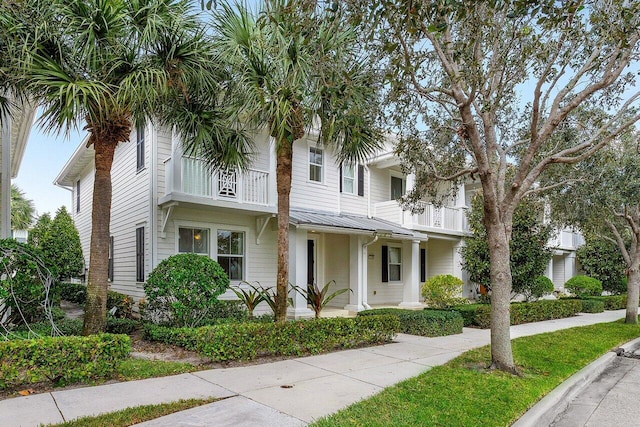 townhome / multi-family property featuring covered porch and a balcony