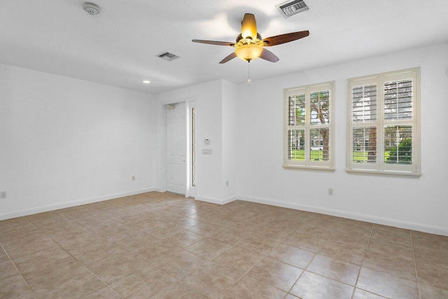 spare room with a textured ceiling, ceiling fan, and light tile patterned flooring