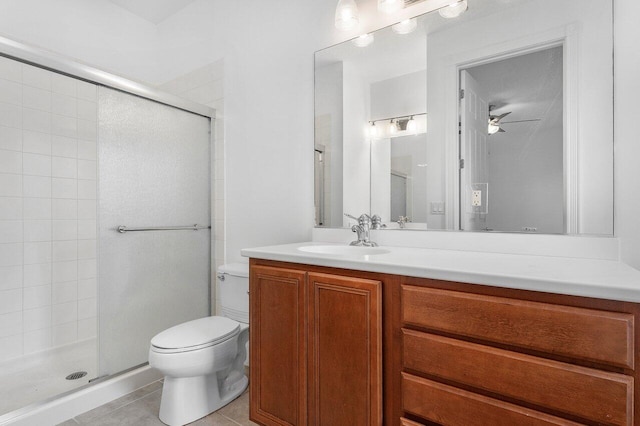 bathroom with tile patterned floors, vanity, ceiling fan, toilet, and a shower with shower door