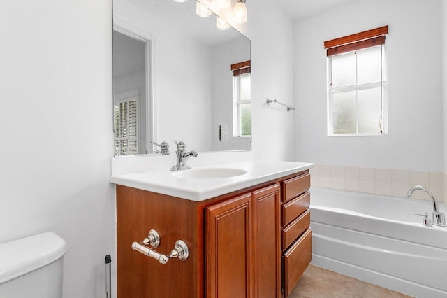 bathroom featuring tile patterned flooring, toilet, plenty of natural light, and a bathing tub