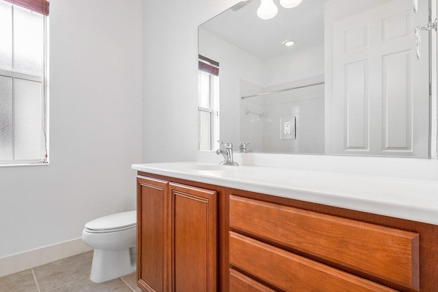 bathroom with tile patterned flooring, vanity, toilet, and tiled shower