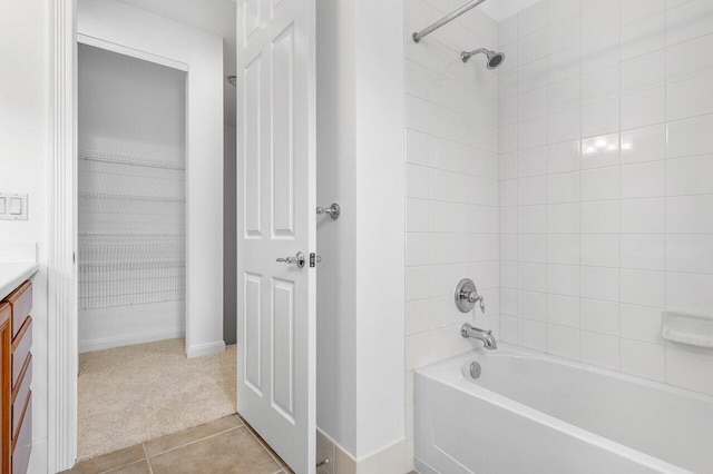 bathroom with tile patterned flooring, vanity, and tiled shower / bath combo