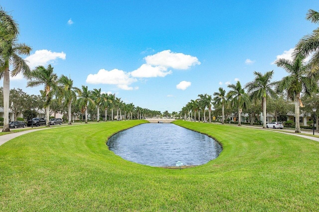 surrounding community with a yard and a water view