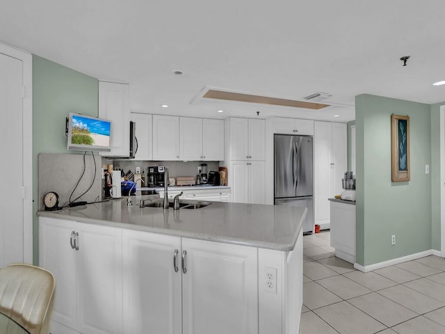 kitchen featuring tasteful backsplash, appliances with stainless steel finishes, sink, white cabinetry, and light tile patterned floors