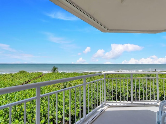 balcony featuring a water view and a view of the beach