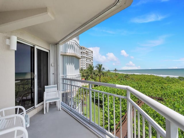 balcony featuring a water view and a view of the beach