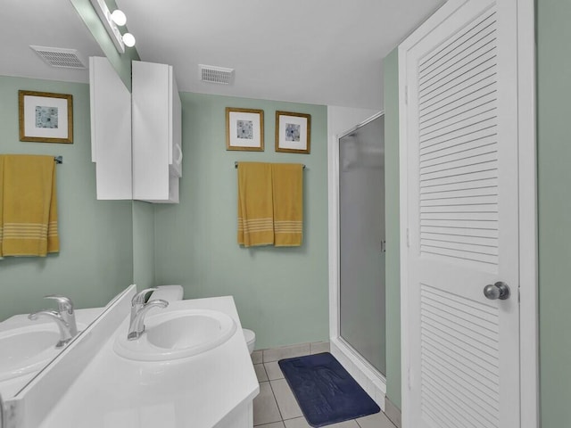 bathroom with vanity, a shower with shower door, toilet, and tile patterned flooring