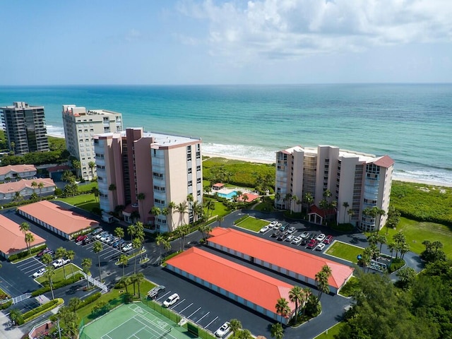 birds eye view of property featuring a water view and a beach view