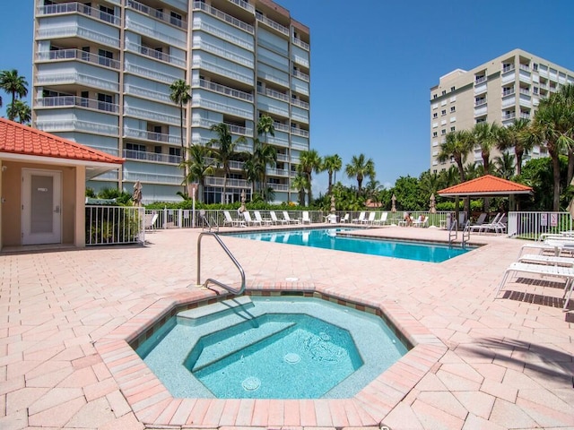 view of pool with a patio and a hot tub