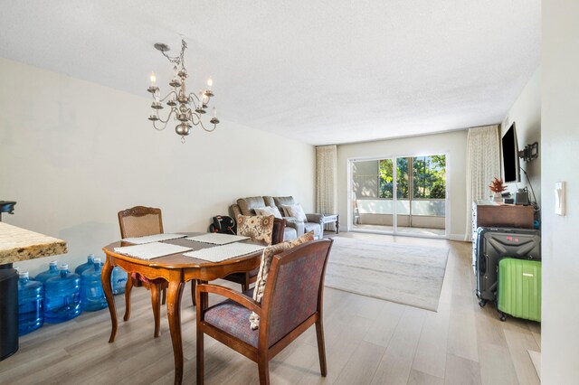 dining area with an inviting chandelier and light hardwood / wood-style floors