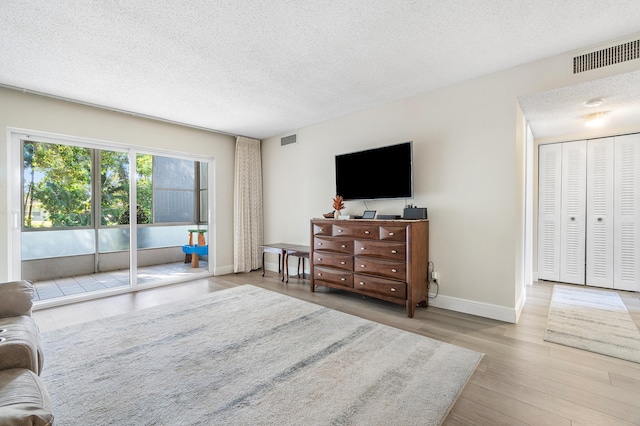 living room featuring a textured ceiling and light hardwood / wood-style floors