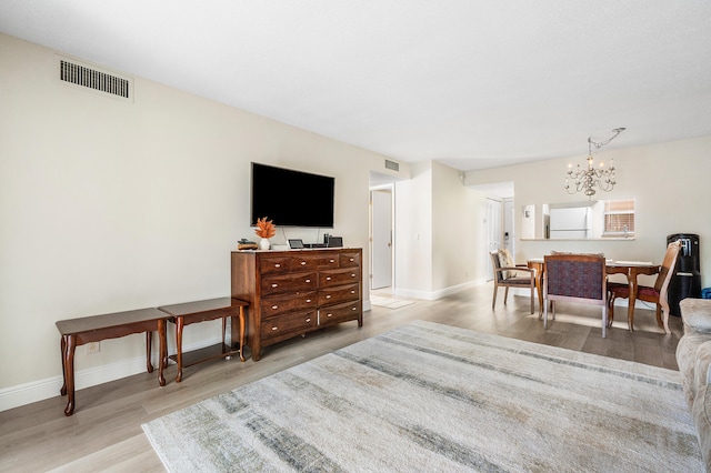 living room with a chandelier and light wood-type flooring