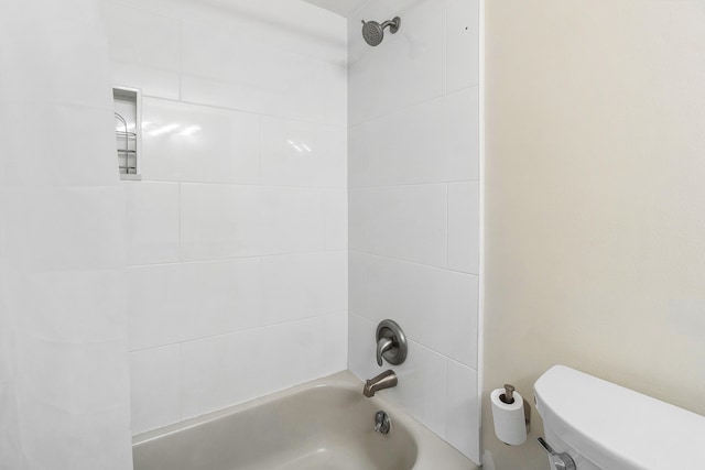 bathroom featuring toilet and tiled shower / bath combo