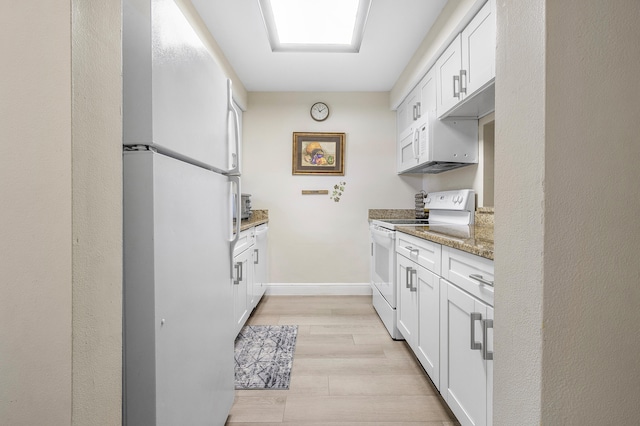 kitchen featuring white appliances, stone counters, white cabinets, and light hardwood / wood-style flooring