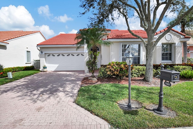 mediterranean / spanish home featuring a front lawn and a garage