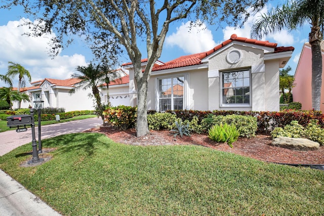 mediterranean / spanish house with a front yard and a garage