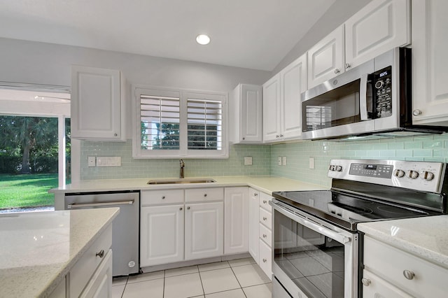 kitchen featuring white cabinets, light tile patterned floors, sink, and appliances with stainless steel finishes