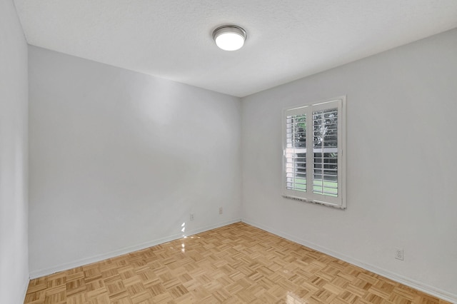 empty room with a textured ceiling and light parquet floors