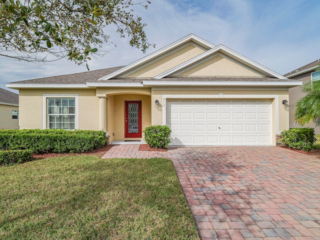 view of front of house with a garage and a front lawn