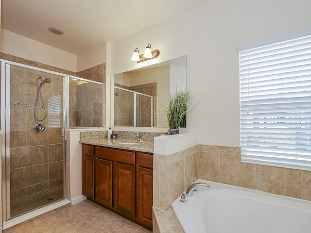 bathroom with tile patterned floors, separate shower and tub, plenty of natural light, and vanity