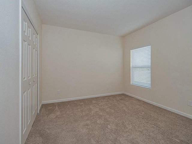 unfurnished room featuring light carpet