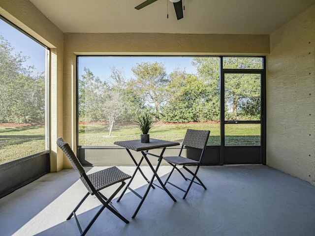 unfurnished sunroom with ceiling fan