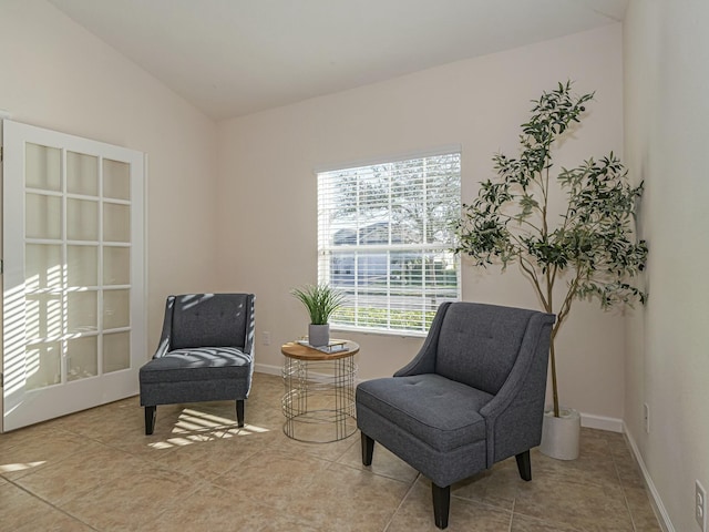 sitting room featuring lofted ceiling and light tile patterned floors