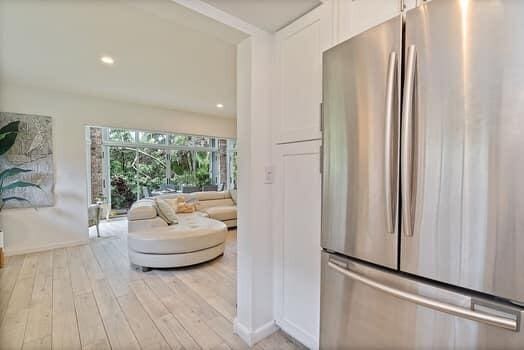 kitchen featuring white cabinetry, light hardwood / wood-style flooring, and stainless steel fridge