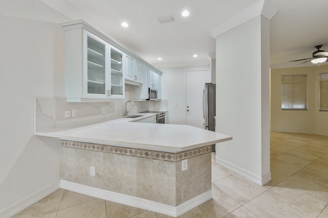 kitchen featuring white cabinetry, kitchen peninsula, stainless steel appliances, and light tile patterned flooring