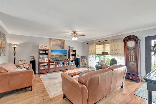 living room with light hardwood / wood-style floors, ornamental molding, plenty of natural light, and ceiling fan