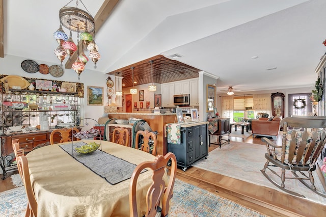 dining area featuring light hardwood / wood-style floors, vaulted ceiling, and ceiling fan