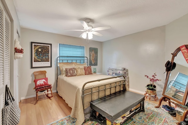 bedroom with a closet, light wood-type flooring, and ceiling fan